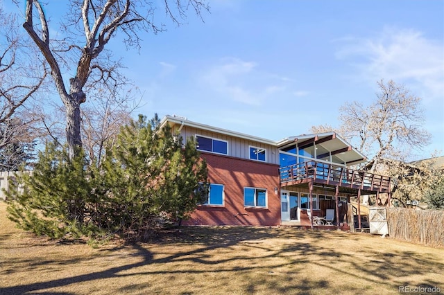 back of property featuring a wooden deck and brick siding