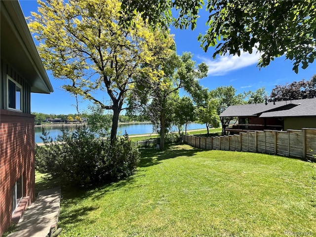 view of yard with fence and a water view