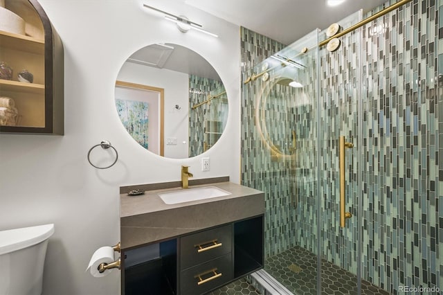 bathroom featuring a shower stall, toilet, and vanity