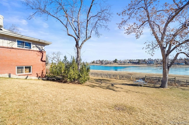 view of yard with a water view and fence