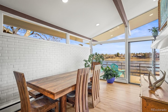 sunroom featuring a wealth of natural light, a baseboard heating unit, a water view, and vaulted ceiling with beams