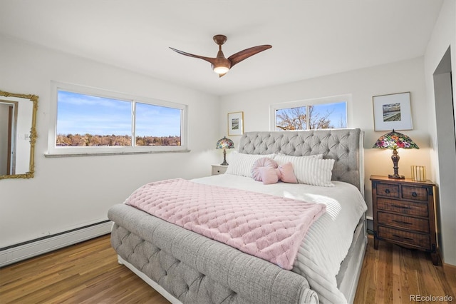 bedroom featuring ceiling fan, a baseboard radiator, and wood finished floors