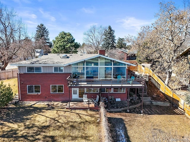 rear view of house with a fenced backyard, a chimney, stairs, a patio area, and brick siding