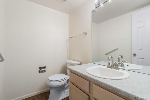 bathroom with vanity, toilet, and hardwood / wood-style floors