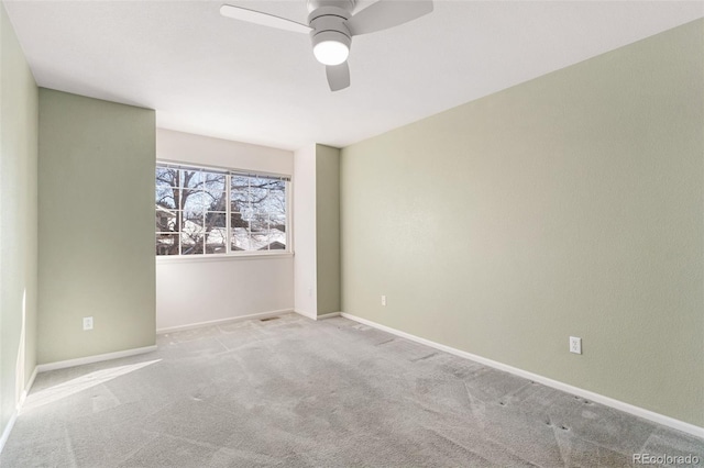 spare room featuring ceiling fan and light colored carpet