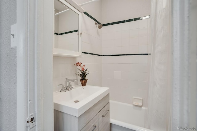 bathroom with backsplash, shower / bath combo with shower curtain, and sink