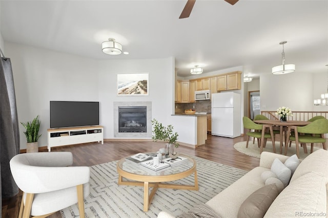 living room with ceiling fan and dark wood-type flooring