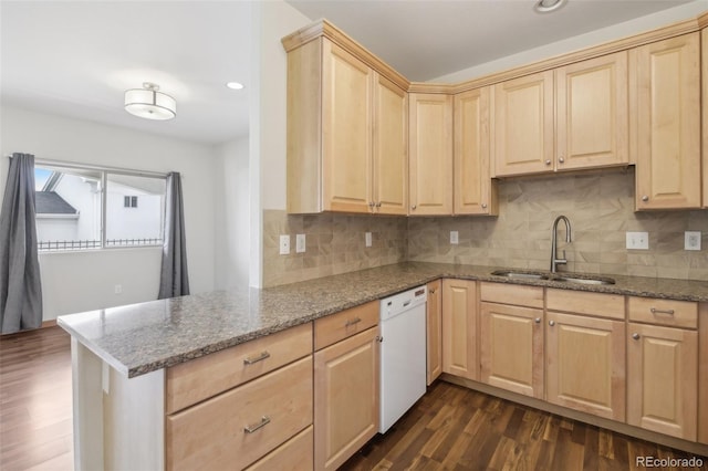 kitchen with kitchen peninsula, light stone counters, sink, and white dishwasher