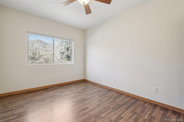 spare room with ceiling fan and dark hardwood / wood-style flooring