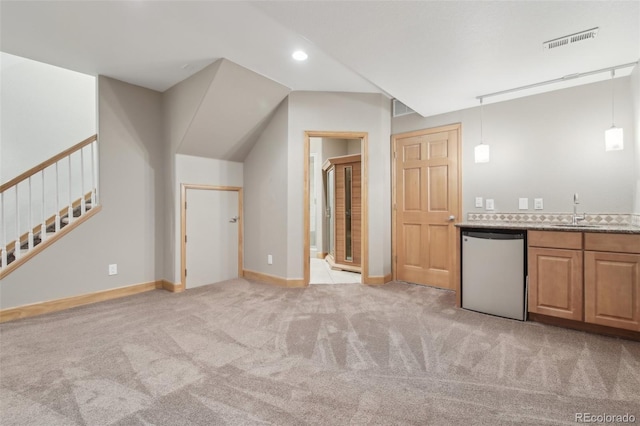 interior space with dishwasher, light carpet, decorative light fixtures, and sink