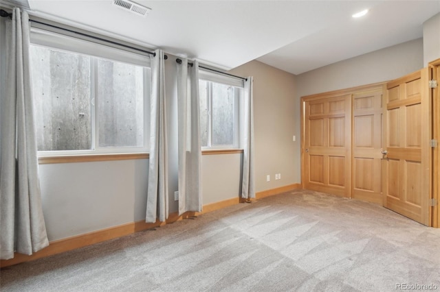 unfurnished bedroom featuring a closet and light colored carpet