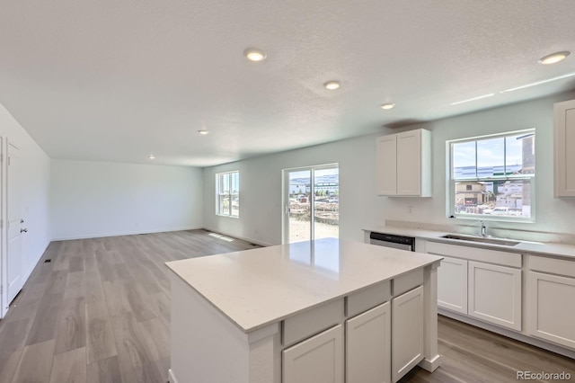 22094 E 39th Pl, Aurora, CO 80019 - kitchen featuring light countertops, a kitchen island, recessed lighting, light wood finished floors, and white cabinets