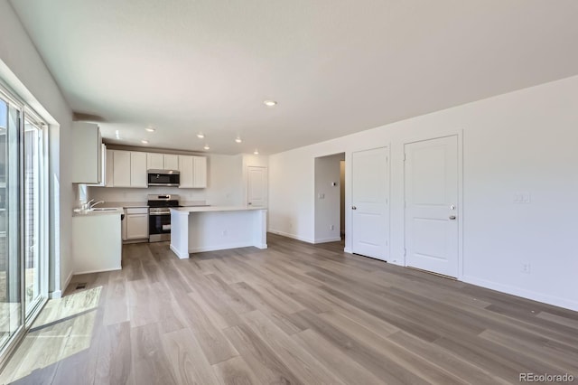22094 E 39th Pl, Aurora, CO 80019 - kitchen with appliances with stainless steel finishes, light countertops, light wood-style floors, white cabinetry, and recessed lighting