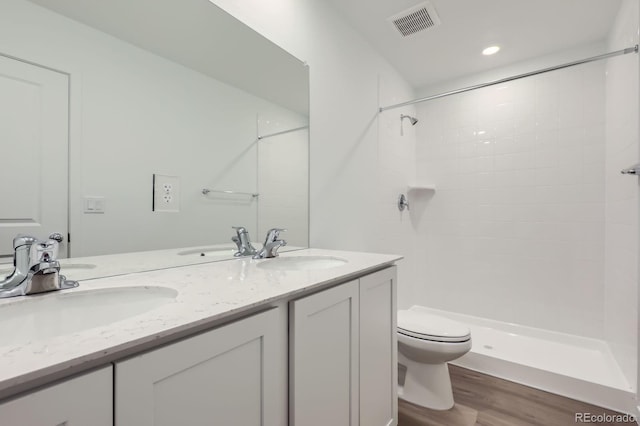 22094 E 39th Pl, Aurora, CO 80019 - full bath featuring wood finished floors, double vanity, tiled shower, and recessed lighting
