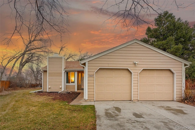 view of front of house with an attached garage, a chimney, a front lawn, and concrete driveway