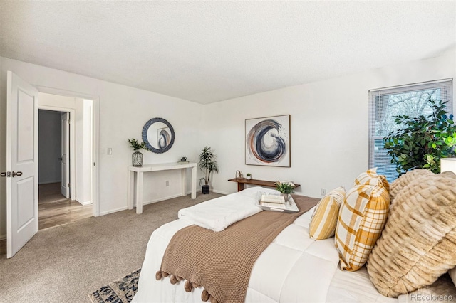 bedroom featuring a textured ceiling, carpet floors, and baseboards