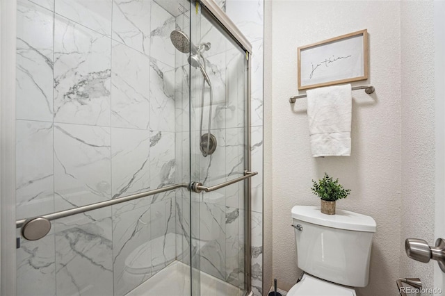 full bathroom featuring a textured wall, a shower stall, and toilet