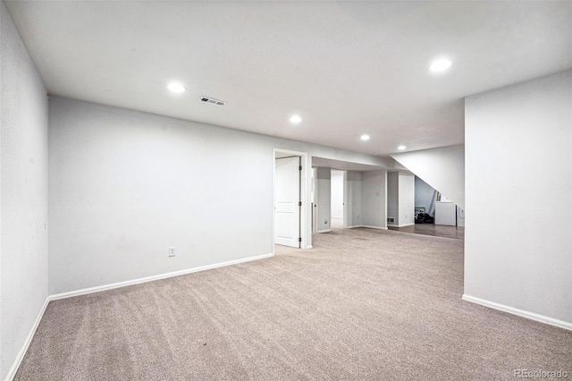 finished below grade area featuring carpet, visible vents, baseboards, and recessed lighting