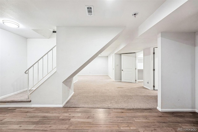 interior space featuring stairs, wood finished floors, visible vents, and baseboards