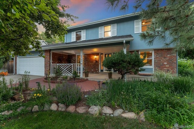 3765 E Easter Dr, Centennial, CO 80122 - traditional home featuring covered porch, brick siding, and driveway