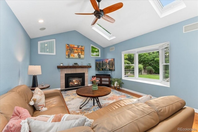 3765 E Easter Dr, Centennial, CO 80122 - living room featuring a skylight, wood finished floors, vaulted ceiling, a ceiling fan, and a glass covered fireplace