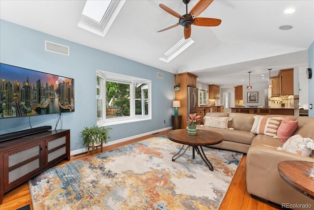 3765 E Easter Dr, Centennial, CO 80122 - living area with a skylight, vaulted ceiling, a ceiling fan, light wood-style floors, and recessed lighting