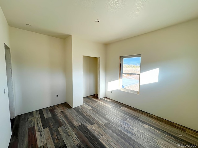 unfurnished bedroom with dark hardwood / wood-style floors and a closet