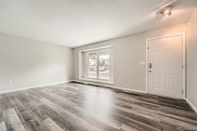 entrance foyer featuring dark wood-type flooring and a textured ceiling