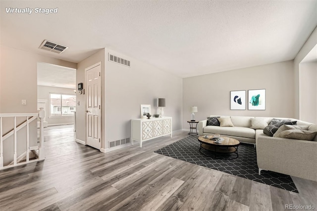 living room featuring a textured ceiling and hardwood / wood-style flooring