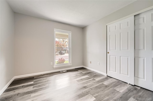 unfurnished bedroom featuring light hardwood / wood-style floors and a closet