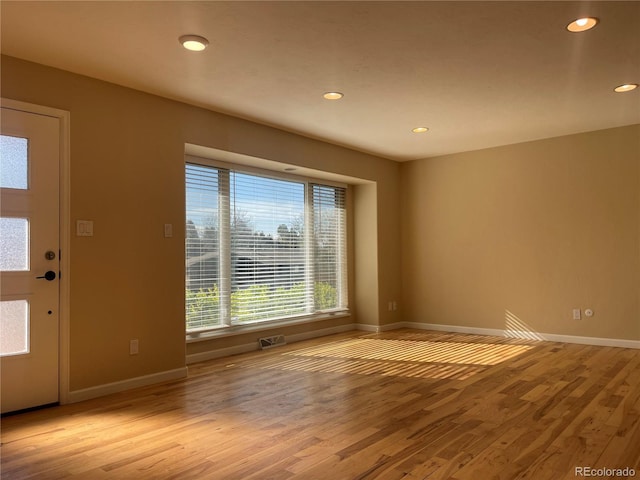 unfurnished room with baseboards, visible vents, recessed lighting, and wood finished floors