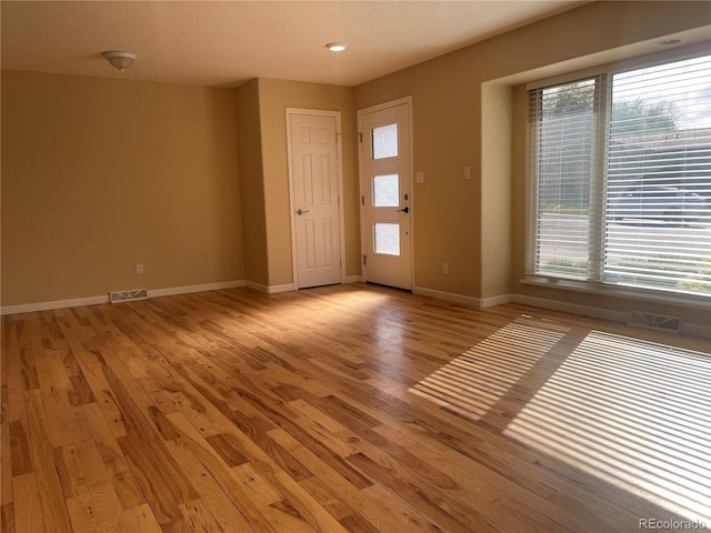 entryway with light wood-type flooring, visible vents, and baseboards