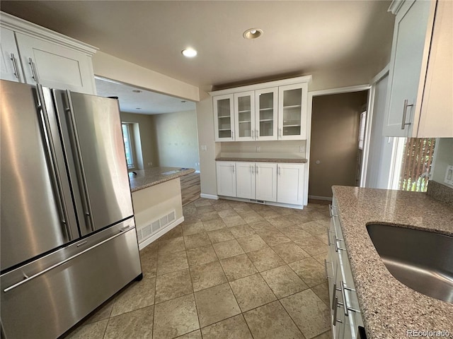 kitchen featuring freestanding refrigerator, visible vents, white cabinets, and recessed lighting