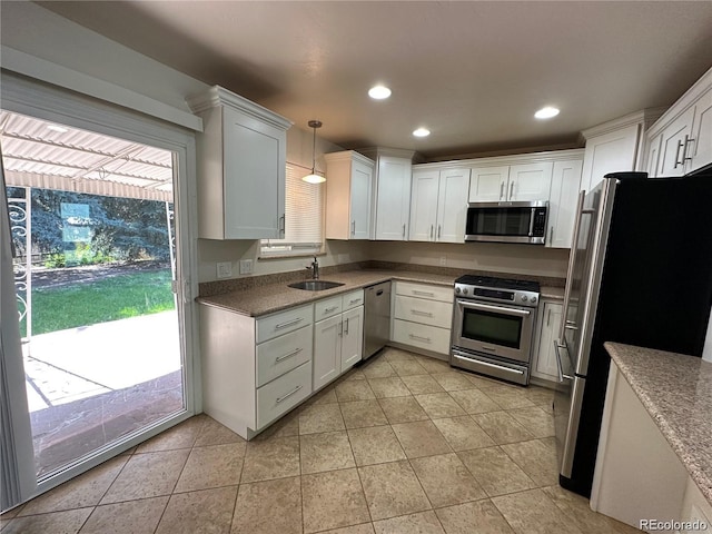 kitchen with a sink, light tile patterned flooring, white cabinets, and appliances with stainless steel finishes