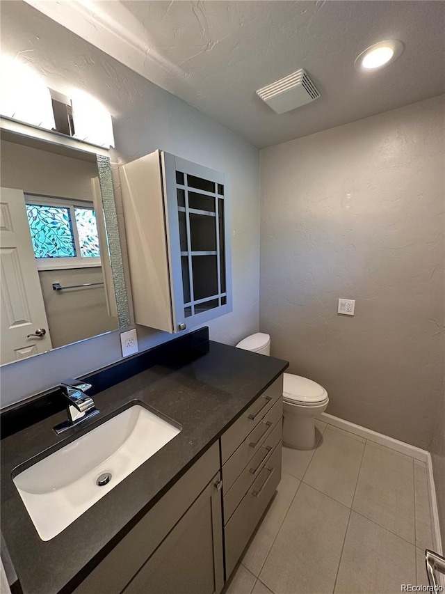 bathroom with recessed lighting, toilet, baseboards, tile patterned flooring, and vanity