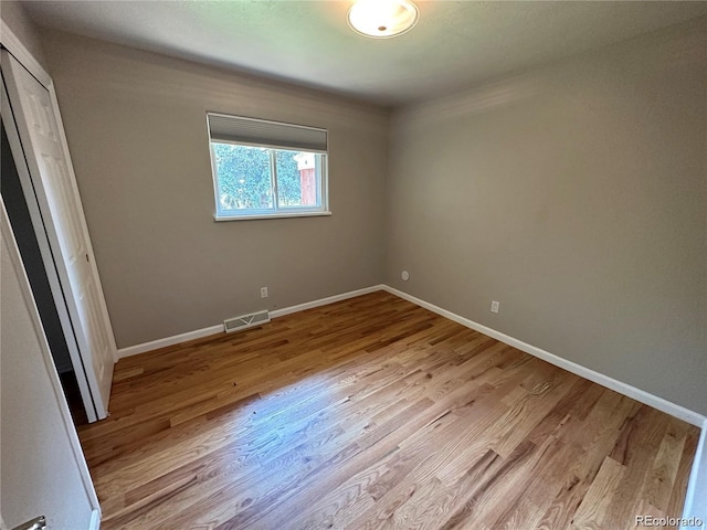 unfurnished bedroom with baseboards, visible vents, and wood finished floors