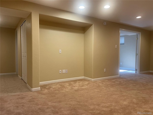 empty room featuring light carpet, baseboards, and recessed lighting