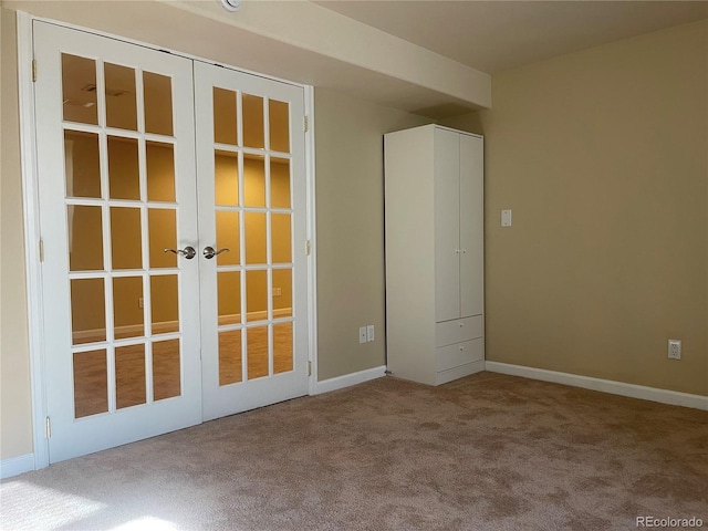 carpeted empty room with baseboards and french doors