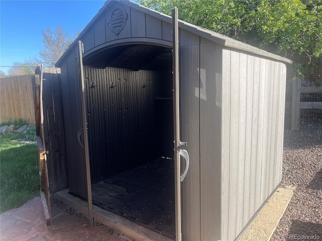 view of shed featuring fence