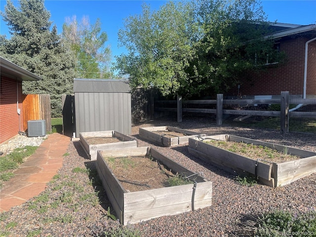 view of yard featuring cooling unit, a shed, a garden, and fence