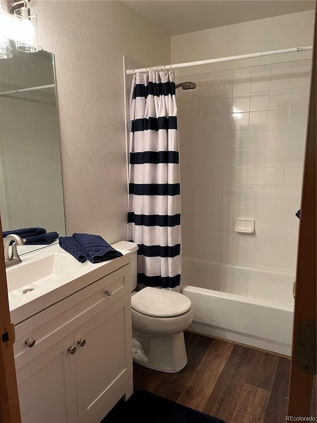 9724 W Euclid Dr, Littleton, CO 80123 - bathroom featuring a textured wall, wood finished floors, vanity, toilet, and shower / bath combo