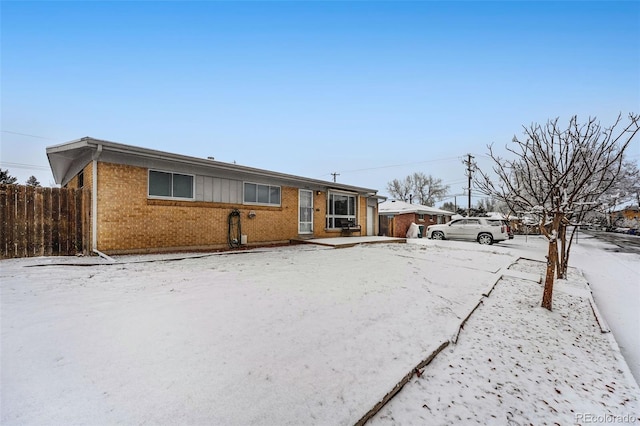 view of front facade with brick siding and fence