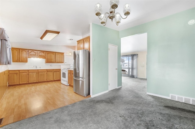 kitchen featuring light carpet, visible vents, light countertops, freestanding refrigerator, and white electric range oven