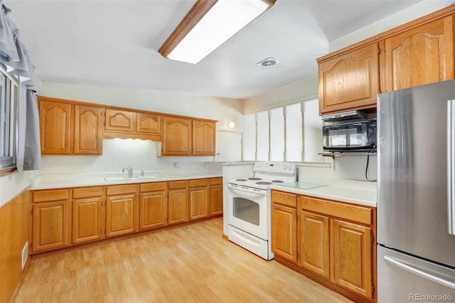 kitchen with light countertops, white electric range, visible vents, freestanding refrigerator, and black microwave