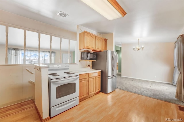 kitchen with black microwave, light wood-style floors, light countertops, light brown cabinetry, and white range with electric cooktop