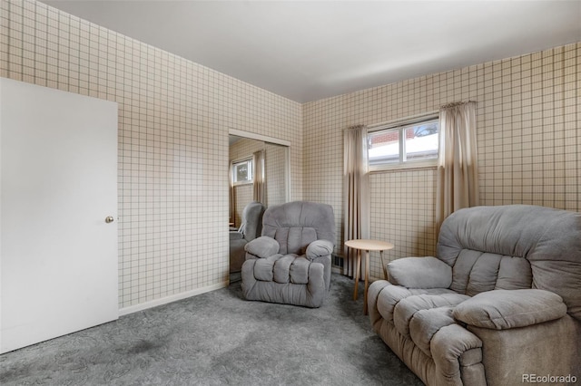 living area featuring tile walls and carpet flooring