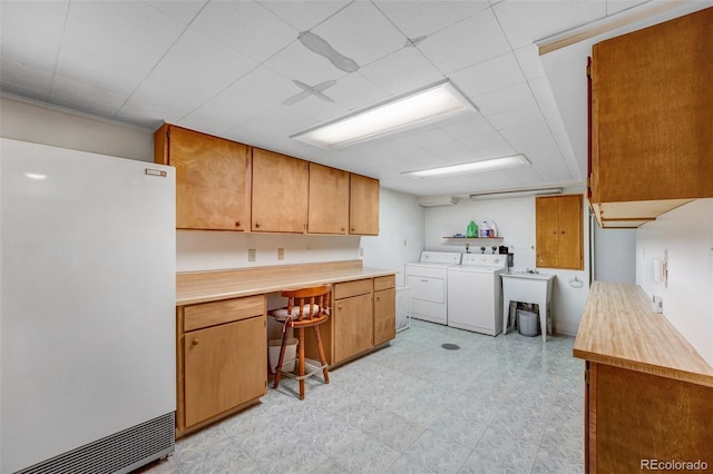 clothes washing area featuring washer and dryer, cabinet space, and light floors