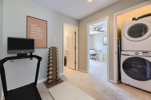 workout room featuring light carpet, ceiling fan, and stacked washer / drying machine