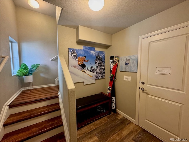 stairs featuring hardwood / wood-style flooring and a textured ceiling