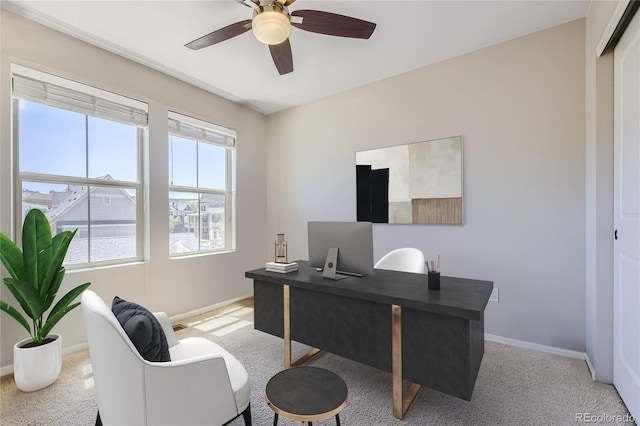 office space featuring plenty of natural light, ceiling fan, and light carpet